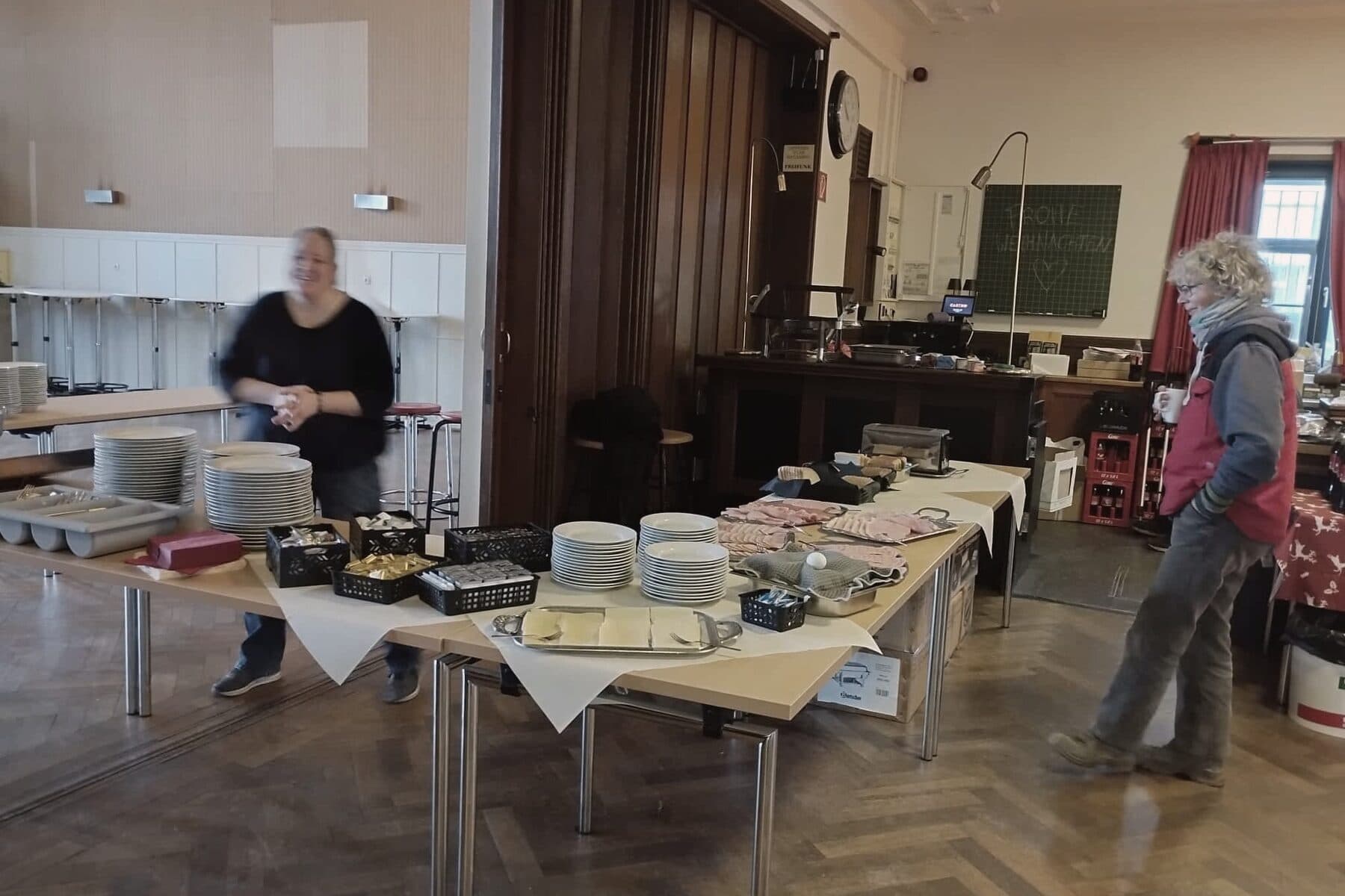 Zwei Helfende richten im Alten Casino das Buffet für den Abend her